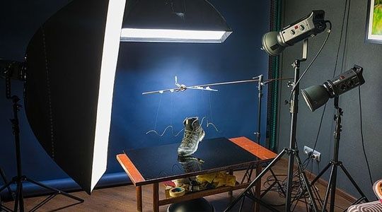Produktvideostudio med kamera, studioblixtar och en sko på ett bord
